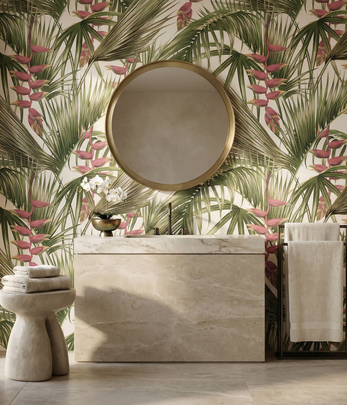 A stylish bathroom featuring tropical palm leaf wallpaper in green and soft pink tones. A round brass-framed mirror hangs above a marble vanity with a modern faucet, while neatly folded towels, a small orchid plant, and warm natural light create a calm, spa-like atmosphere.