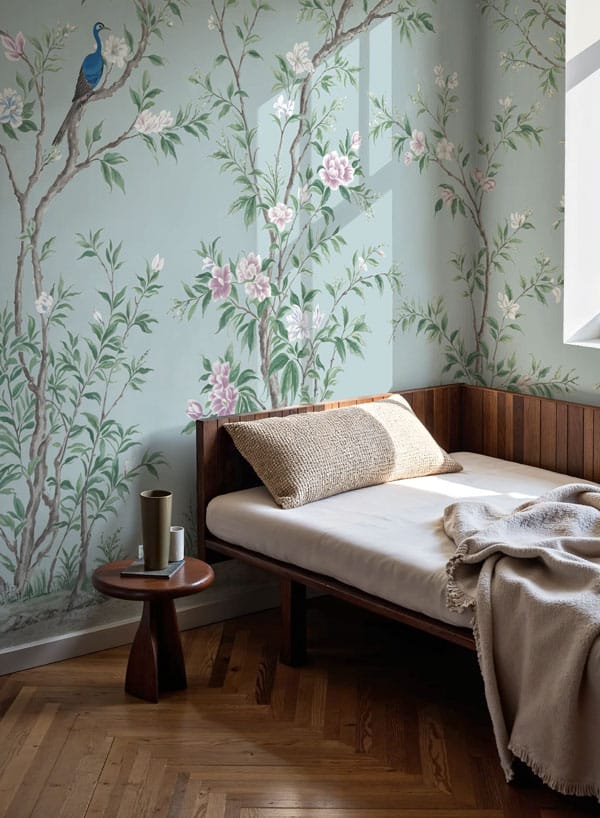 teal floral chinoiserie wall mural with climbing trees, flowers and birds set behind a daybed with light streaming in